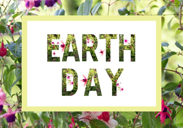 Photo le concept de la journée mondiale de la terre lettrage de la journée de la terre avec des plantes et des fleurs merveilleuses