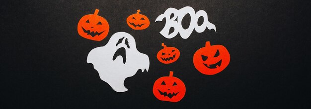 Concept de joyeuses fêtes d'halloween. Chauves-souris, citrouilles et fantômes sur fond noir