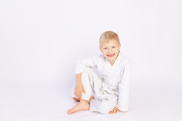 Concept de judo et de sport, garçon blond assis en judogi