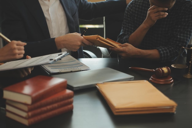 Photo concept de justice et de droit le conseiller juridique présente au client un contrat signé avec un marteau et le droit juridique ou juridique ayant une réunion d'équipe dans un cabinet d'avocats en arrière-plan