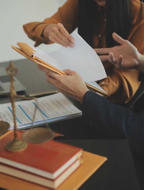 Photo concept de justice et de droit le conseiller juridique présente au client un contrat signé avec un marteau et le droit juridique ou juridique ayant une réunion d'équipe dans un cabinet d'avocats en arrière-plan