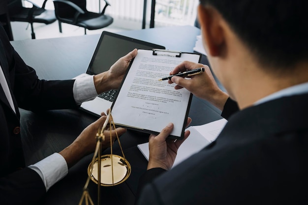 Concept de justice et de droit Gavel sur le bloc sonore dans la main Juge masculin dans une salle d'audience travaillant avec des livres de droit des documents rapporter l'affaire sur la table dans un bureau moderne