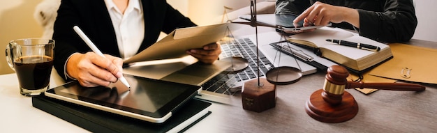 Photo concept de justice et de droit gavel sur le bloc sonore dans la main juge masculin dans une salle d'audience travaillant avec des livres de droit des documents rapporter l'affaire sur la table dans un bureau moderne