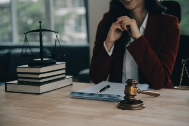 Concept de justice et de droitJuge masculin dans une salle d'audience avec le marteau travaillant avec l'ordinateur et l'accostage des lunettes de clavier sur la table à la lumière du matin