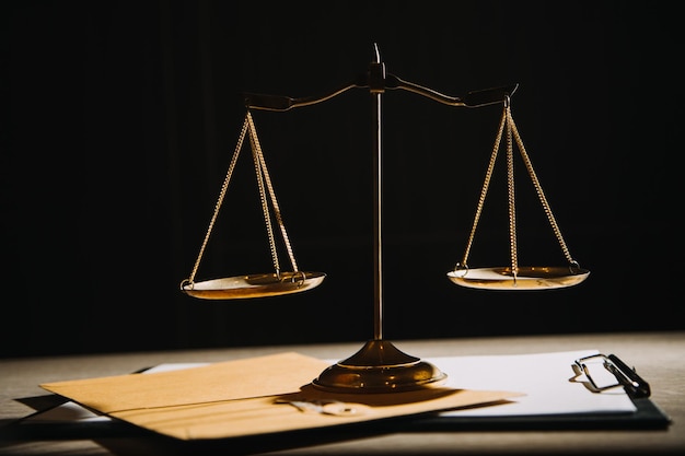 Concept de justice et de droitJuge masculin dans une salle d'audience avec le marteau travaillant avec un ordinateur et des lunettes de clavier d'amarrage sur la table à la lumière du matin