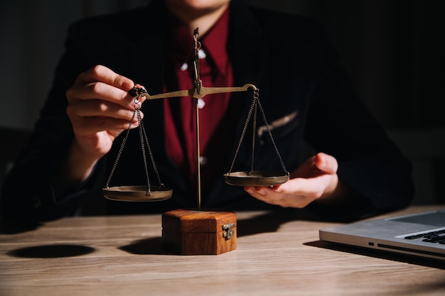 Concept de justice et de droitJuge masculin dans une salle d'audience avec le marteau travaillant avec un ordinateur et des lunettes de clavier d'amarrage sur la table à la lumière du matin