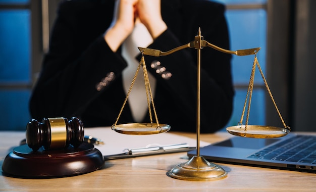 Concept de justice et de droitJuge masculin dans une salle d'audience avec le marteau travaillant avec un ordinateur et des lunettes de clavier d'amarrage sur la table à la lumière du matin