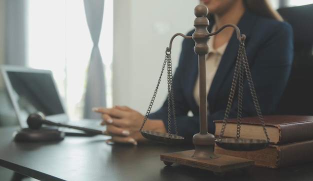 Concept de justice et de droitJuge masculin dans une salle d'audience avec le marteau travaillant avec un ordinateur et des lunettes de clavier d'amarrage sur la table à la lumière du matin