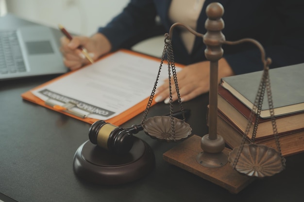 Concept de justice et de droitJuge masculin dans une salle d'audience avec le marteau travaillant avec un ordinateur et des lunettes de clavier d'amarrage sur la table à la lumière du matin