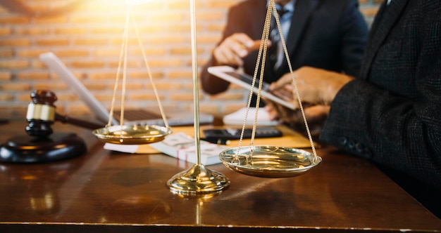 Concept de justice et de droitJuge masculin dans une salle d'audience avec le marteau travaillant avec un ordinateur et des lunettes de clavier d'amarrage sur la table à la lumière du matin