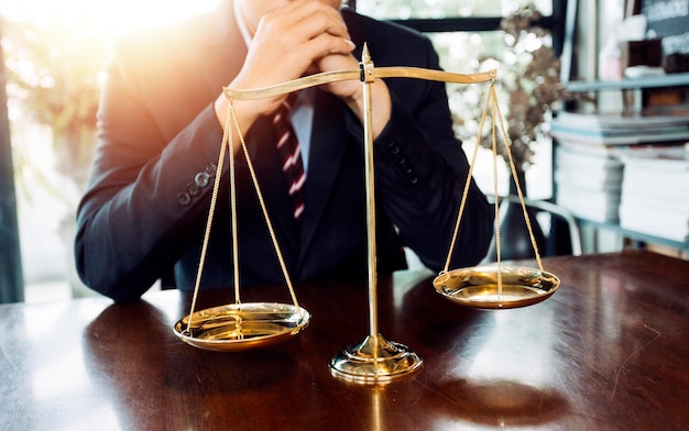 Concept de justice et de droitJuge masculin dans une salle d'audience avec le marteau travaillant avec un ordinateur et des lunettes de clavier d'amarrage sur la table à la lumière du matin