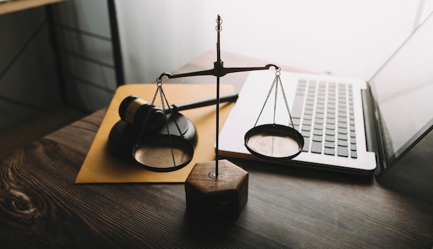 Concept de justice et de droitJuge masculin dans une salle d'audience avec le marteau travaillant avec un ordinateur et des lunettes de clavier d'amarrage sur la table à la lumière du matin