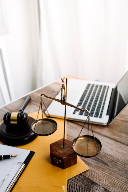 Concept de justice et de droitJuge masculin dans une salle d'audience avec le marteau travaillant avec un ordinateur et des lunettes de clavier d'amarrage sur la table à la lumière du matin