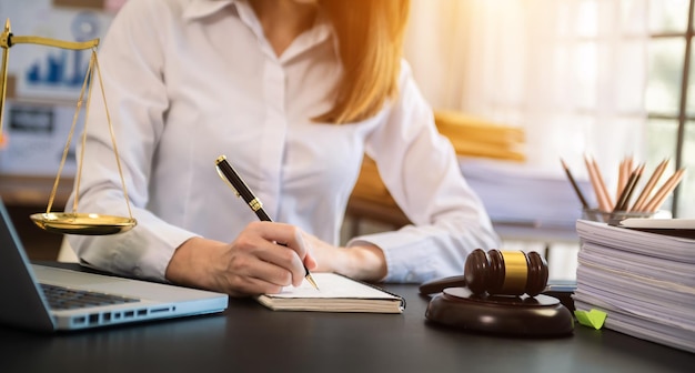 Concept de justice et de droitJuge masculin dans une salle d'audience avec le marteau travaillant avec une tablette et des lunettes de clavier d'accueil sur la table à la lumière du matin