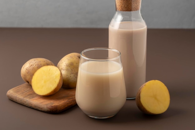 Concept de lait alternatif verre avec du lait de pomme de terre sur fond brun