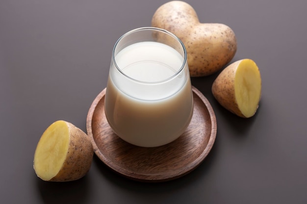 Concept de lait alternatif verre avec du lait de pomme de terre sur fond brun