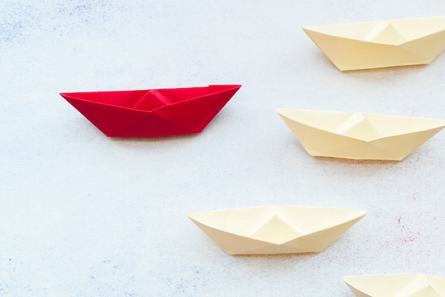 Photo concept de leadership à l'aide de papier rouge expédier entre blanc sur fond