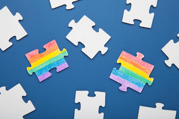 Concept LGBT en tant que partie de la société deux puzzle avec la coloration du drapeau des minorités sexuelles sur fond bleu foncé