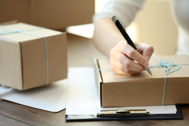 Concept de livraison Femme signe des papiers parmi les colis se bouchent