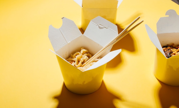 le concept de livraison de nourriture sur fond jaune nouilles dans des boîtes