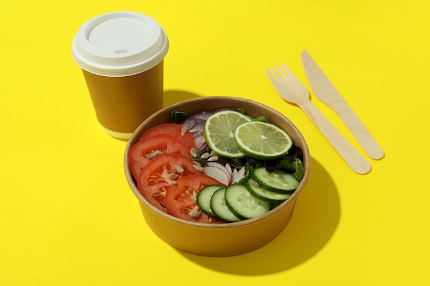 Concept de livraison de nourriture avec salade de légumes sur fond jaune