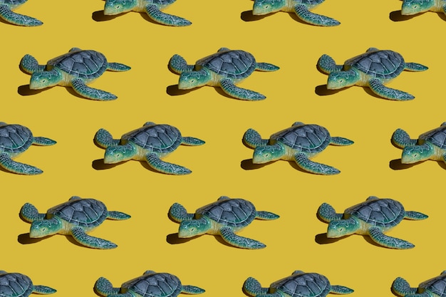 Photo concept lumineux d'été - tortue bleue sur fond jaune. motif lumineux sans soudure