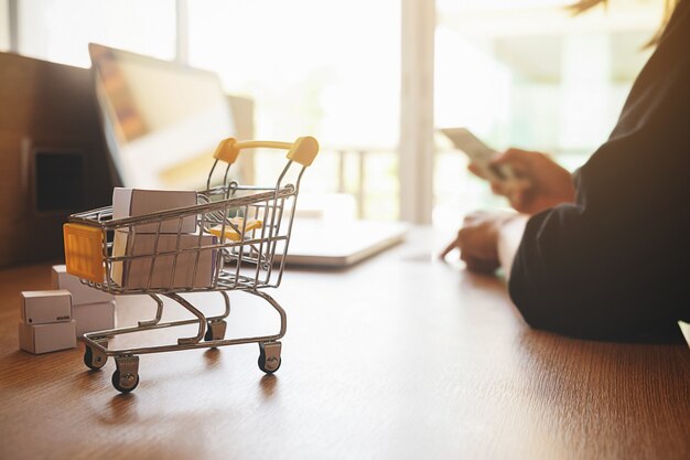 Concept de magasinage en ligne Internet avec ordinateur portable et shopping-cart.Vintage ton effet de filtre rétro, flou artistique (mise au point sélective)