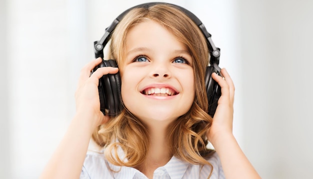 Concept De Maison, De Technologie Et De Musique - Petite Fille Avec Des écouteurs à La Maison