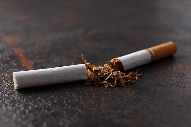 Concept de mal de fumer la cigarette sur fond texturé foncé