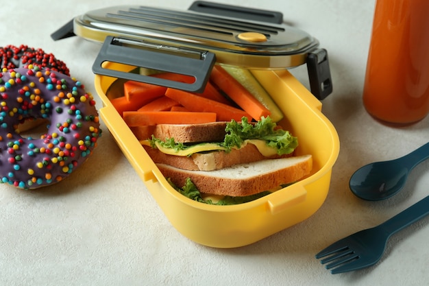 Photo concept de manger savoureux avec boîte à lunch sur une table texturée blanche