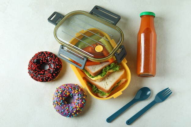 Concept de manger savoureux avec boîte à lunch sur une table texturée blanche