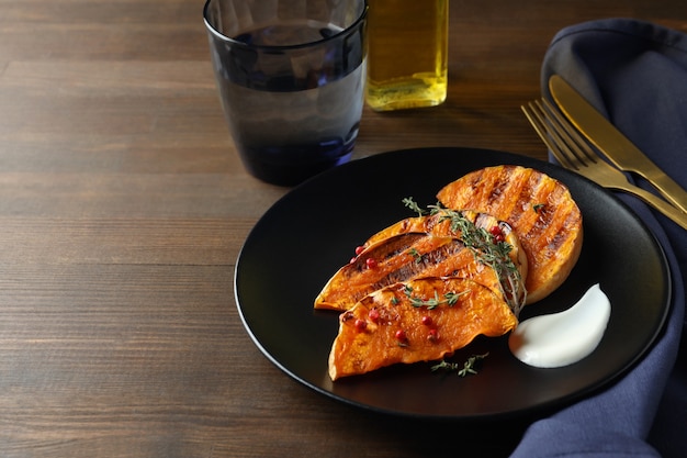 Concept de manger savoureux avec de la citrouille au four sur fond en bois.