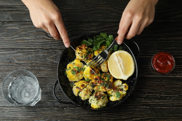 Concept de manger savoureux avec du chou-fleur au four sur fond en bois.