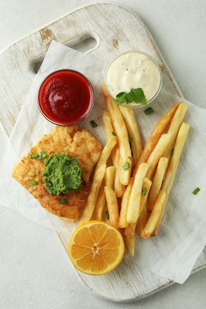 Concept de manger savoureux avec du poisson frit et des frites isolés