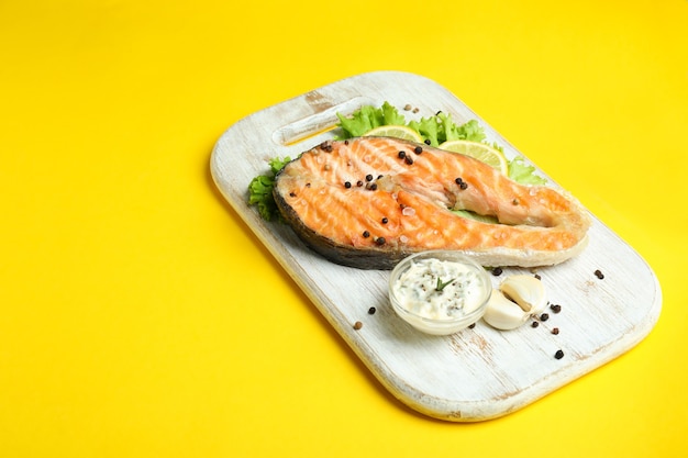 Concept de manger savoureux avec du saumon grillé sur fond jaune