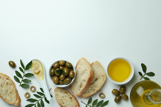 Concept de manger savoureux avec de l'huile d'olive sur une surface blanche