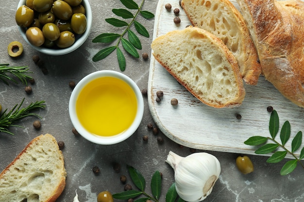 Concept de manger savoureux avec de l'huile d'olive sur une table texturée grise