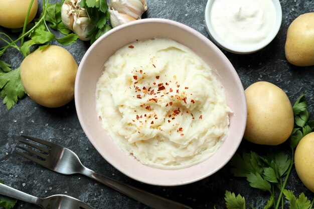 Concept de manger savoureux avec de la purée de pommes de terre sur une table fumée noire