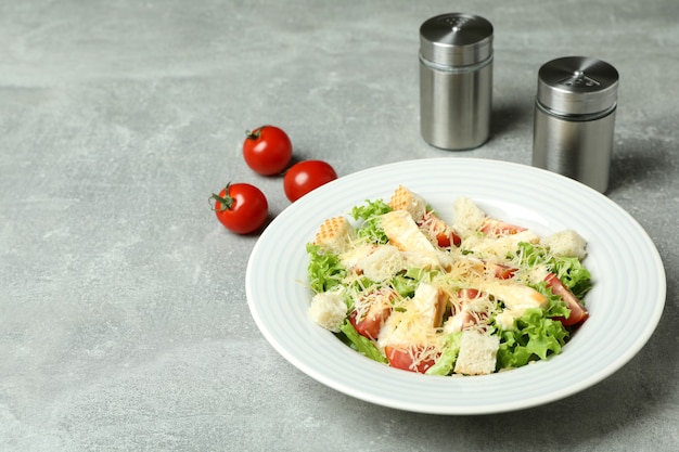 Concept de manger savoureux avec salade César sur fond texturé gris