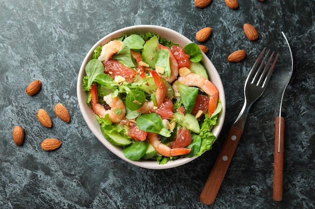 Concept de manger savoureux avec une salade de crevettes sur une table fumée noire