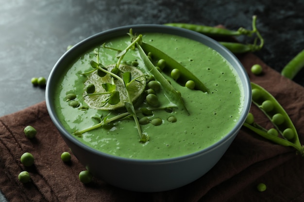 Concept de manger savoureux avec de la soupe aux pois sur une table fumée noire