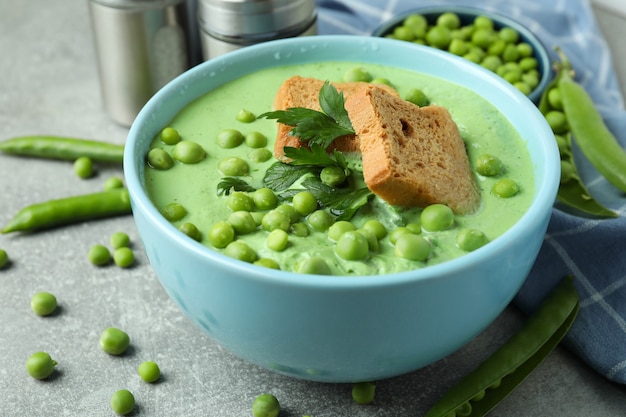 Concept de manger savoureux avec de la soupe aux pois sur une table texturée grise