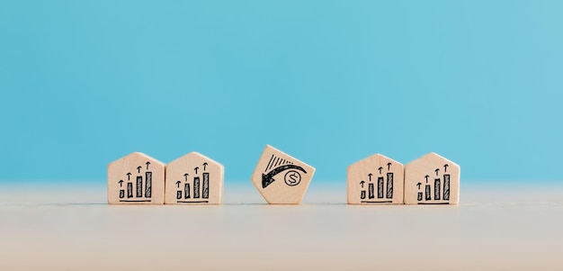 Concept de marché de l'immobilier et du logement à l'aide d'un modèle de maison en bois sur fond bleu