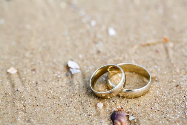 Concept de mariage - alliances se trouvent sur le sable