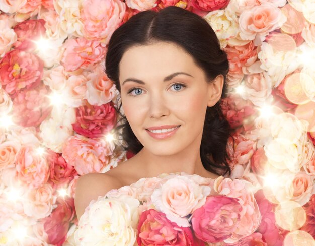 concept de mariée et de beauté - belle femme avec fond plein de roses