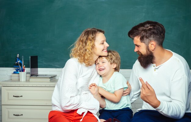 Concept de mathématiques pour l'éducation parentale Concept d'école Mathématiques pour les enfants Les enfants se préparent pour l'école Heureux jeune couple qui se tient avec son fils à la remise des diplômes Journée de la famille