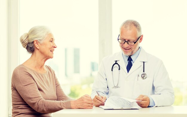 concept de médecine, d'âge, de soins de santé et de personnes - réunion d'une femme âgée souriante et d'un médecin dans un cabinet médical