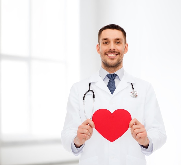 concept de médecine, de profession et de soins de santé - médecin de sexe masculin souriant avec coeur rouge et stéthoscope