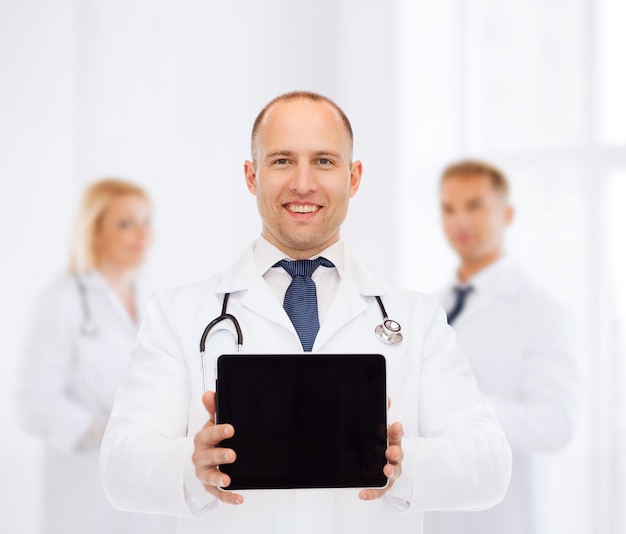 concept de médecine, de publicité et de travail d'équipe - médecin souriant avec stéthoscope montrant un écran d'ordinateur tablette pc sur un groupe de médecins