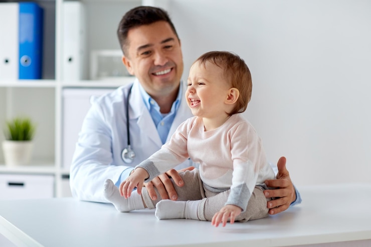 Photo concept de médecine, de soins de santé, de pédiatrie et de personnes - médecin ou pédiatre heureux tenant le bébé lors d'un examen médical à la clinique